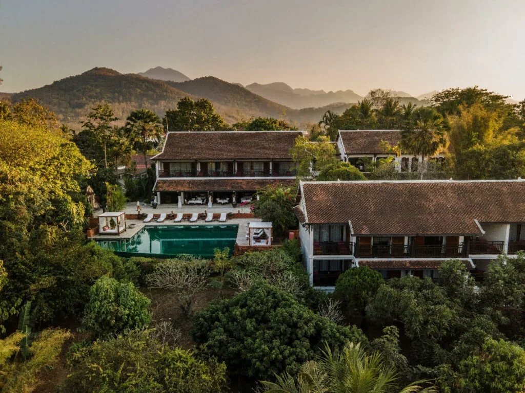 Aerial view of La Résidence Phou Vao's hilltop pool and mountain backdrop in Luang Prabang