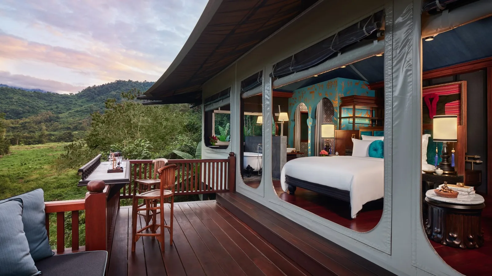 A Bill Bensley-designed tented villa bedroom at Rosewood Luang Prabang, overlooking the jungle valley
