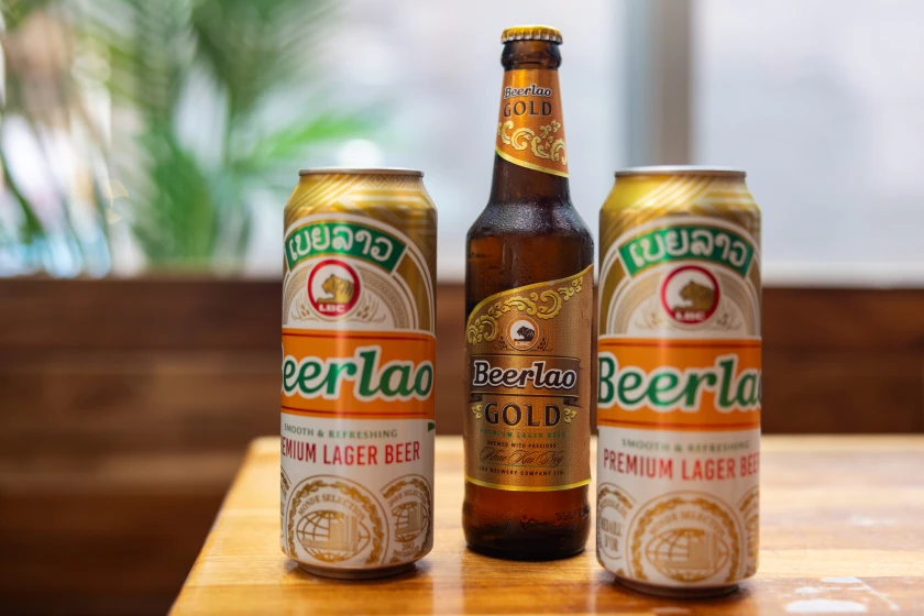 Vientiane, Laos: A Three-Day Pause in the Universe 7 Cans and a bottle of Beerlao, Laos' national lager, on a wooden table in Vientiane